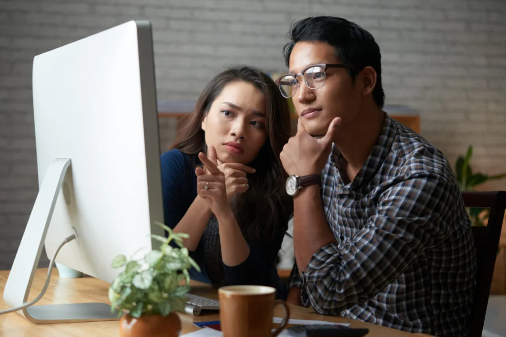 Deux collegues regardent un ecran et travaillent