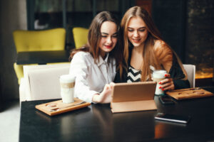 Deux femmes très jeunes consultent du contenu sur une tablette