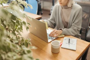 une femme travaille a son bureau avec une tasse da cafe